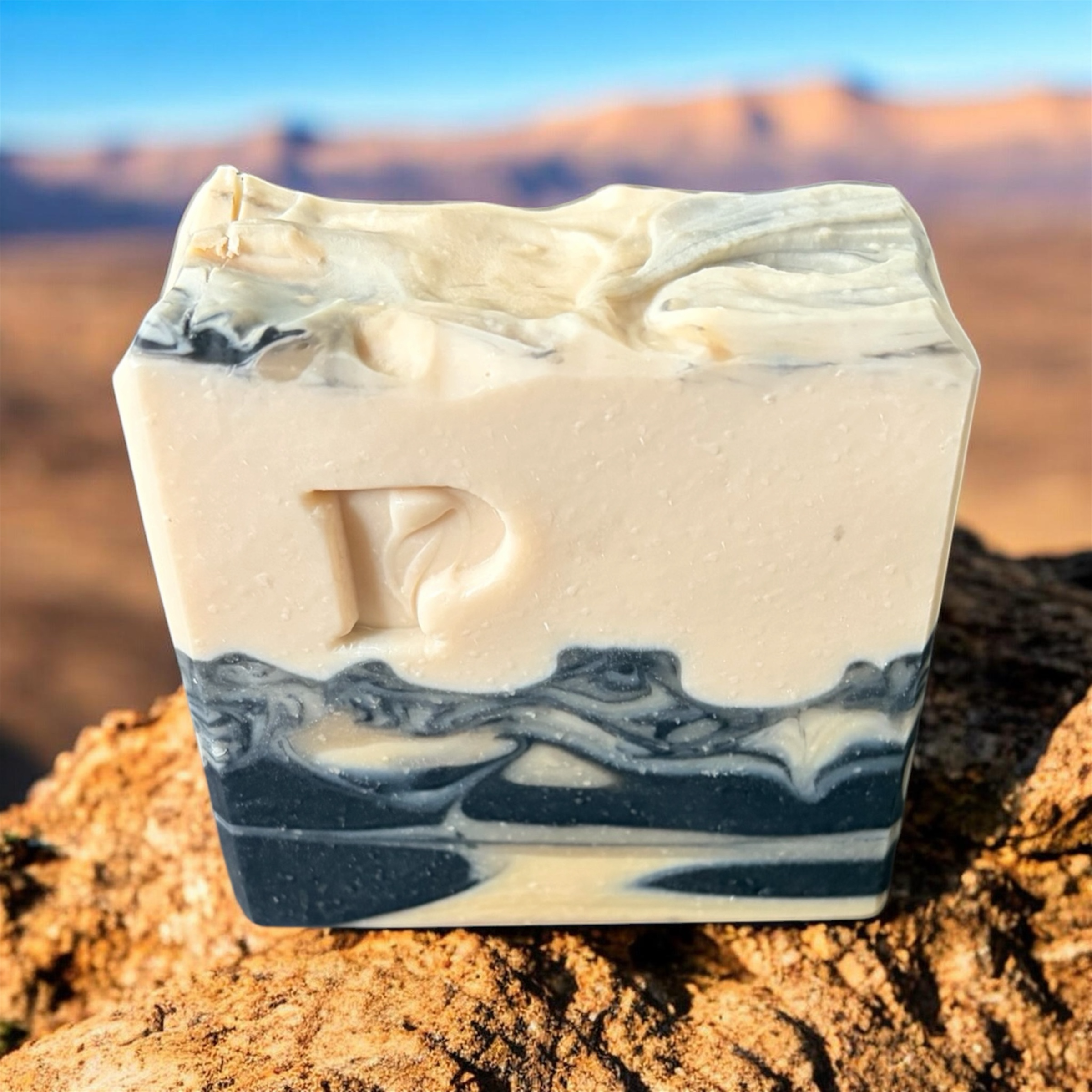 Prudent Preservations Artisan Swirl Bar Soap with embossed P logo, white and charcoal grey marbled design, handcrafted for cleansing and nourishing.